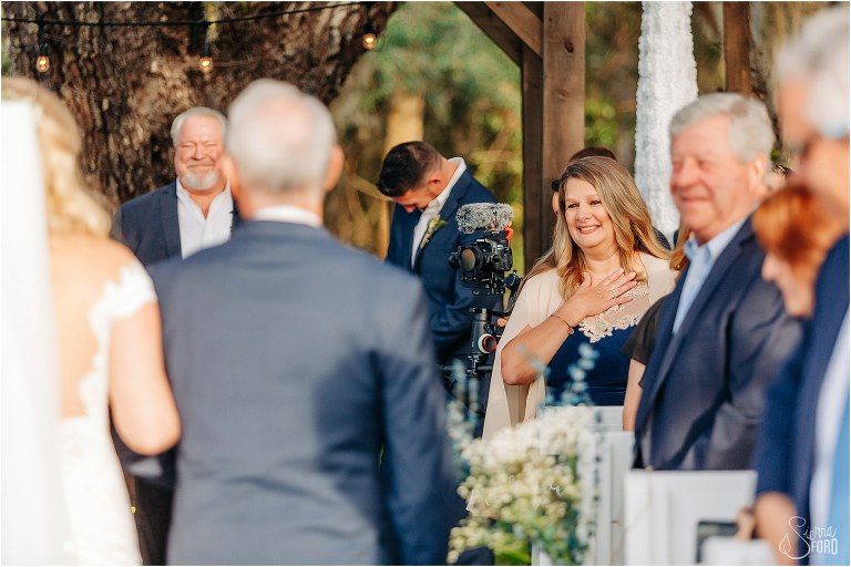 mother of the groom gets emotional as bride comes down aisle at Ever After Farms wedding