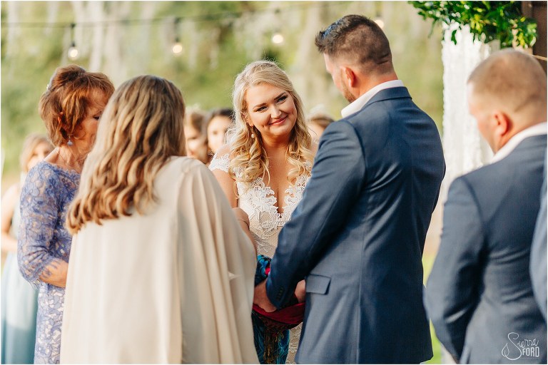 bride looks lovingly at groom during handfasting ceremony at Ever After Farms wedding