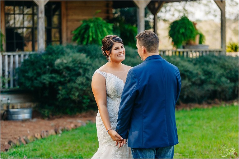 bride beams at her groom seeing her for first time before Isola Farms wedding