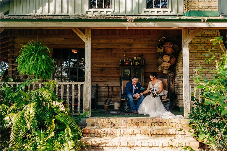 bride and groom sit in rocking chairs together on porch of farmhouse at Isola Farms wedding
