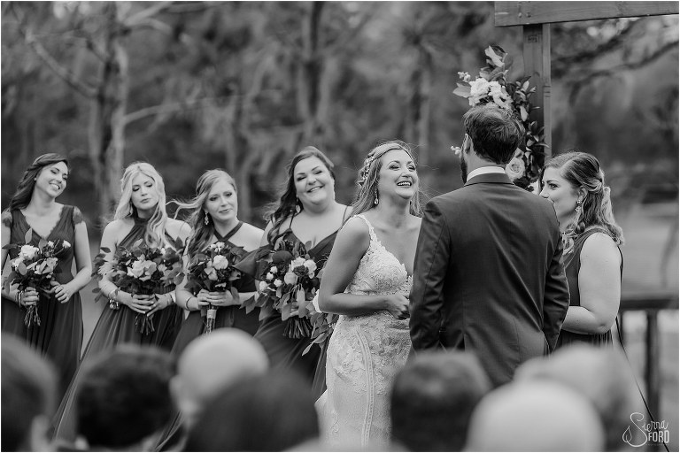 bride laughs as they exchange vows at lakefront wedding ceremony