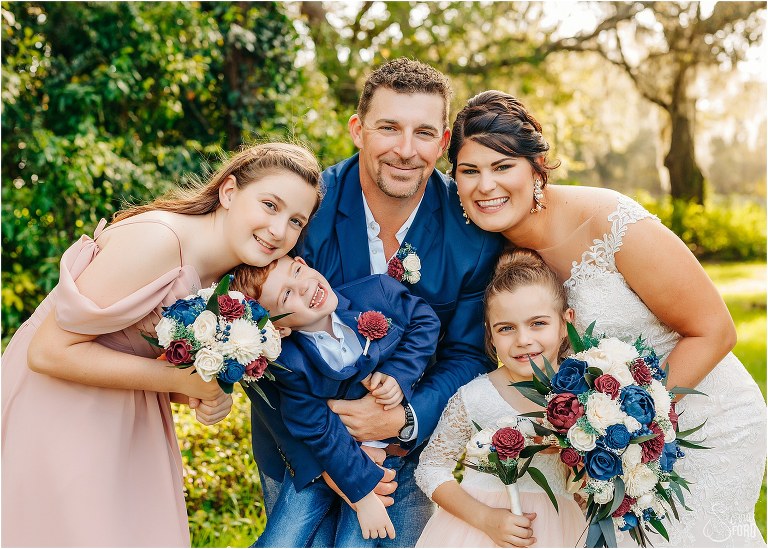 bride and groom smile with their children after Isola Farms wedding