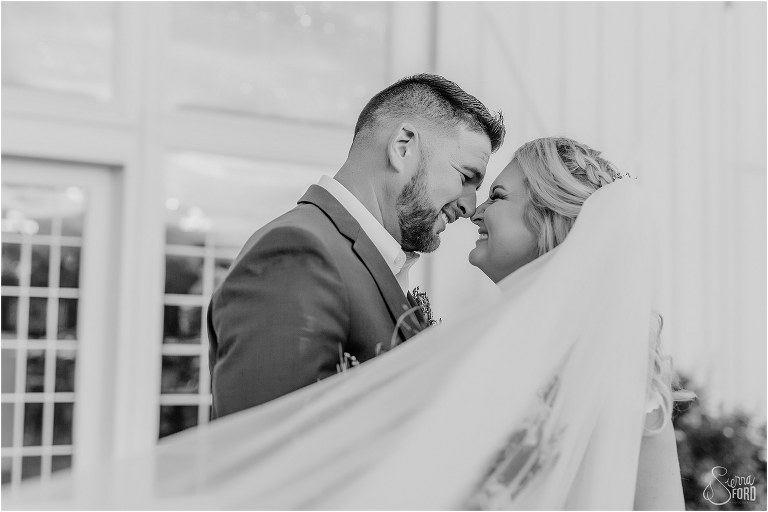 bride and groom grin nose to nose surrounded by bride's veil at Ever After Farms wedding