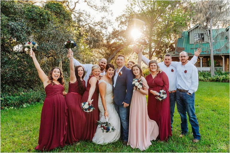 wedding party cheers and group hugs bride and groom at Isola Farms wedding