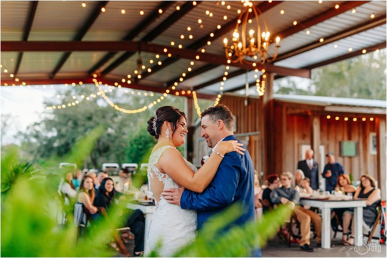 bride and groom beam at each other as they share first dance as husband and wife at Isola Farms wedding reception