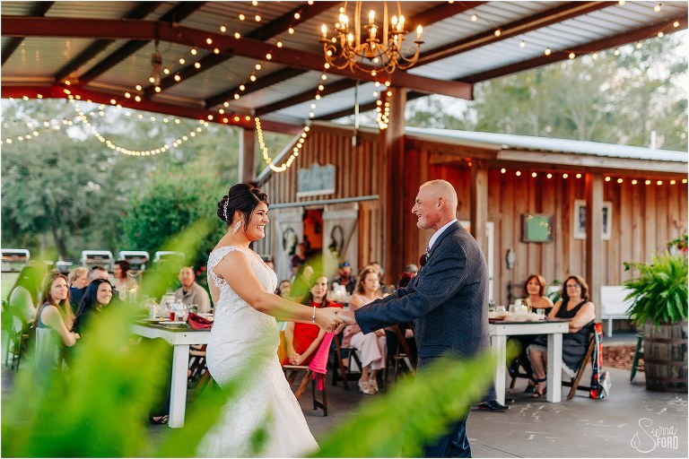 bride laughs with father as they share dance together at Isola Farms wedding reception
