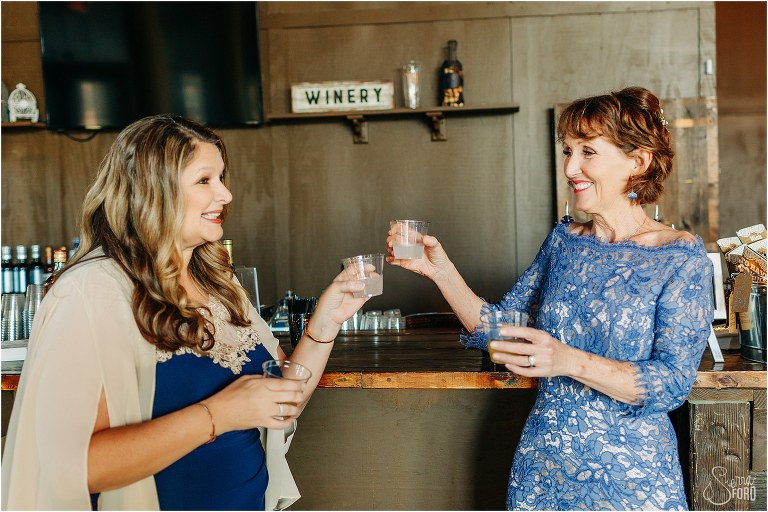mothers of the bride and groom take a shot of tequila before Ever After Farms wedding