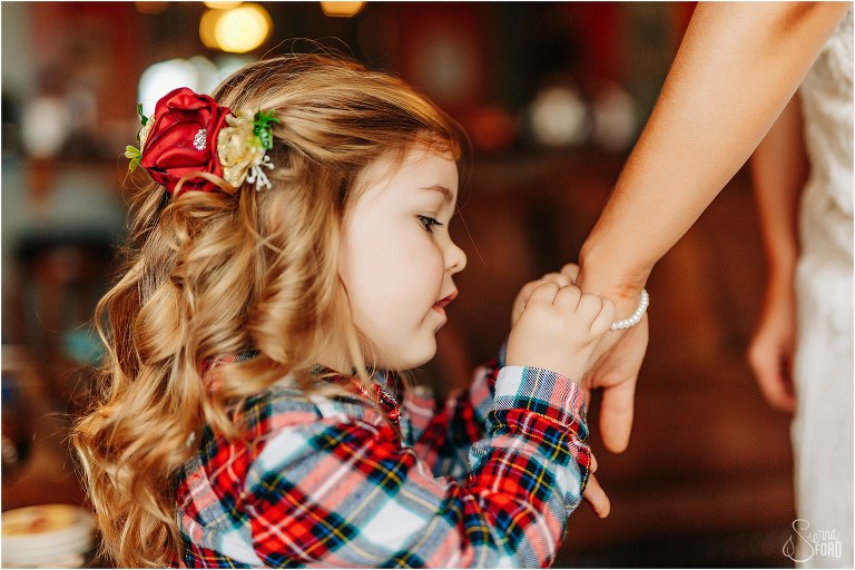 flower girl fasten bride's pearl bracelet before lakefront wedding