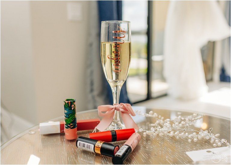 bride's personalized champagne flute surrounded by lipstick options before Bella Collina wedding