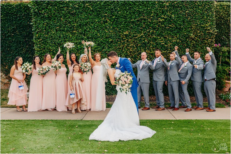 wedding party cheers as bride and groom kiss at Bella Collina wedding