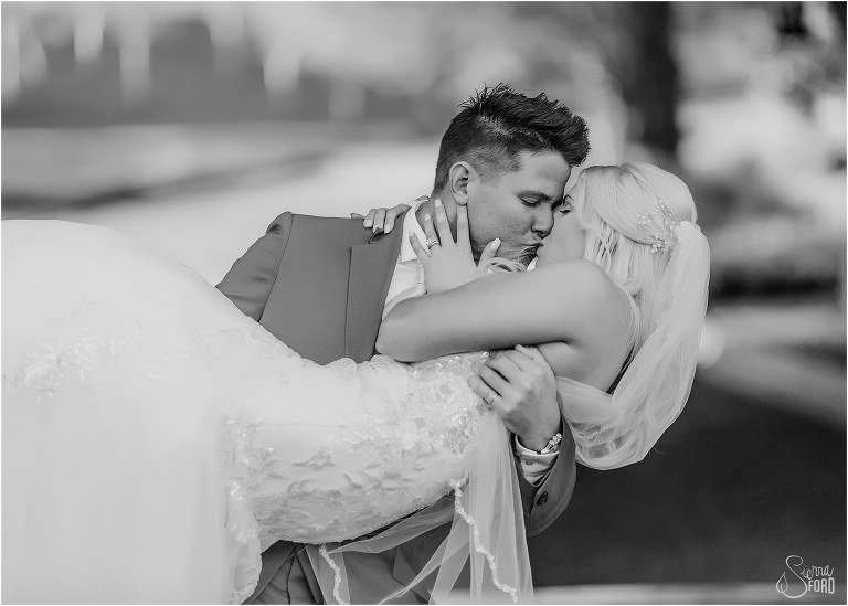 groom kisses bride as he picks her up and spins her at Bella Collina wedding