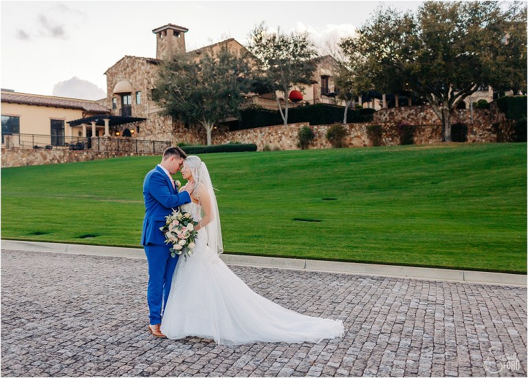 bride and groom share quiet moment forehead to forehead in front of clubhouse at Bella Collina wedding