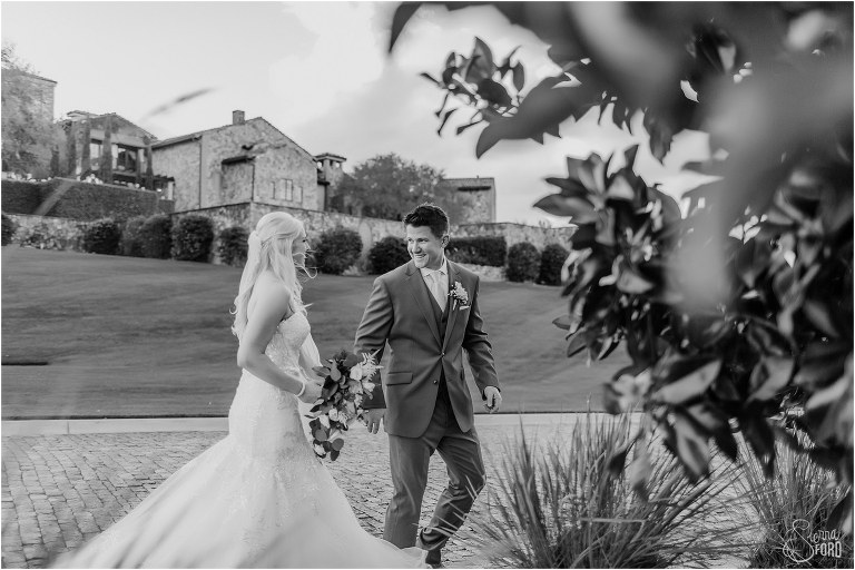 bride and groom laugh as they run down street together at Bella Collina wedding