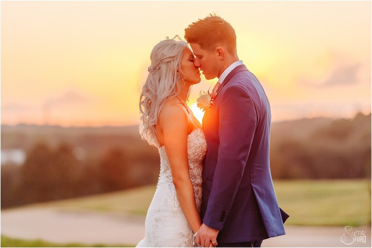 setting sun shines through as couple nearly kiss at Bella Collina wedding