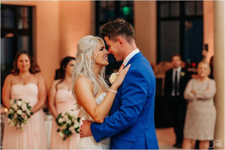 bride and groom smile at each other as they share first dance as husband and wife at Bella Collina wedding reception