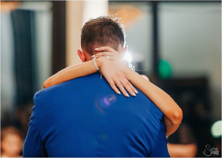 bride holds groom close during first dance at Bella Collina wedding reception