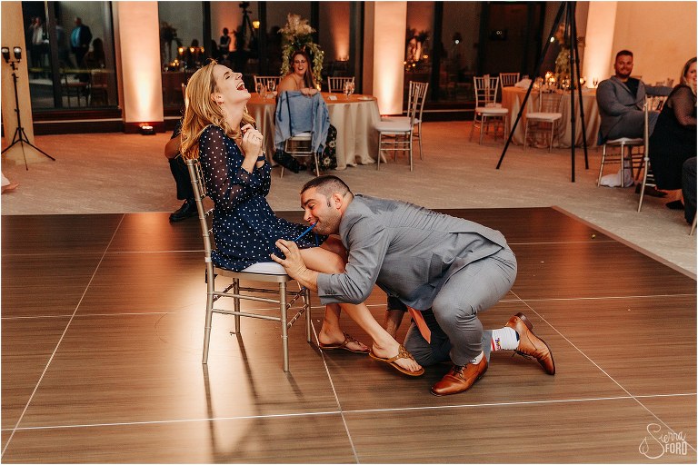 groomsmen who caught garter places it on woman who caught bouquet at Bella Collina wedding