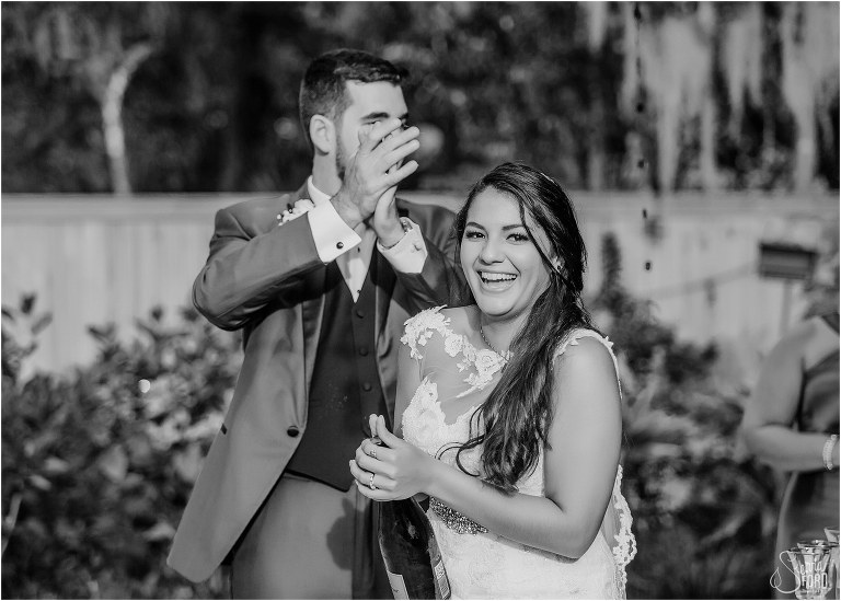 groom claps as bride laughs popping the cork on champagne to celebrate Mount Dora tiny wedding