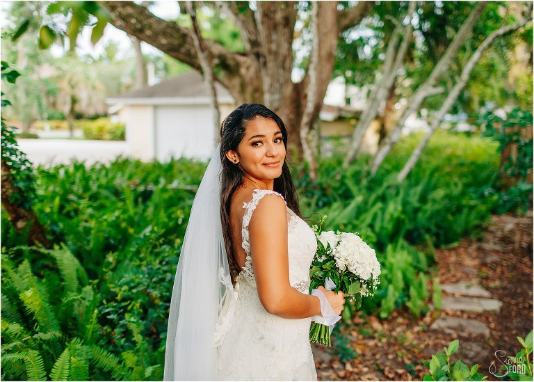 bride looks over shoulder in gardens before Mount Dora elopement wedding