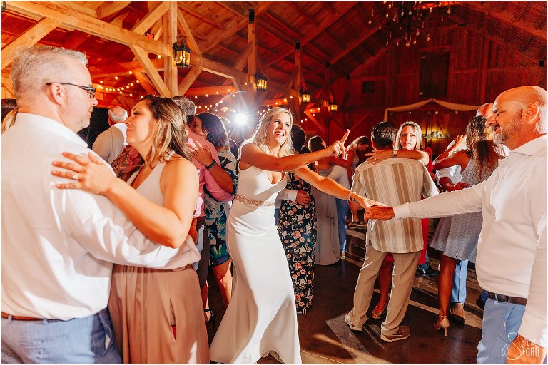 bride shakes her finger playfully at groom as they dance together at rustic barn wedding
