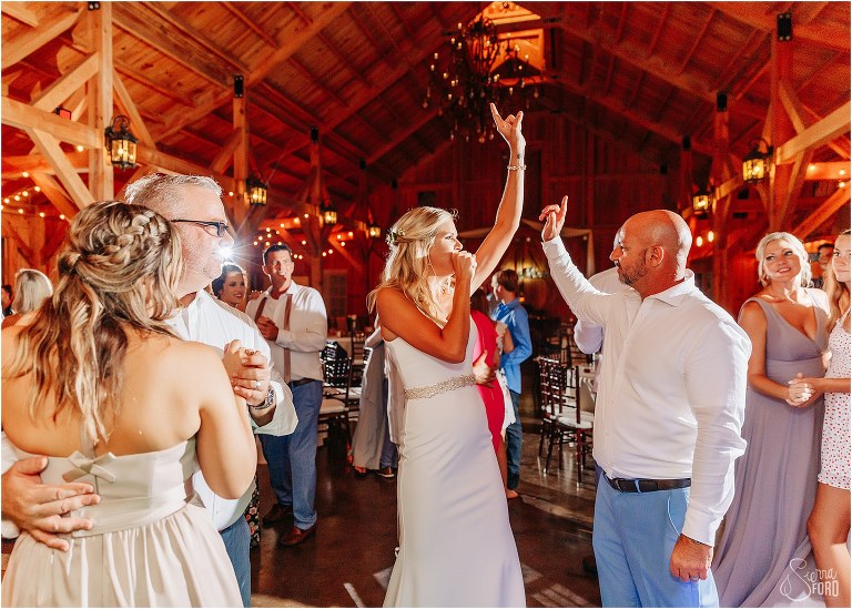 bride and groom goof off together on the dance floor during last dance at rustic barn wedding