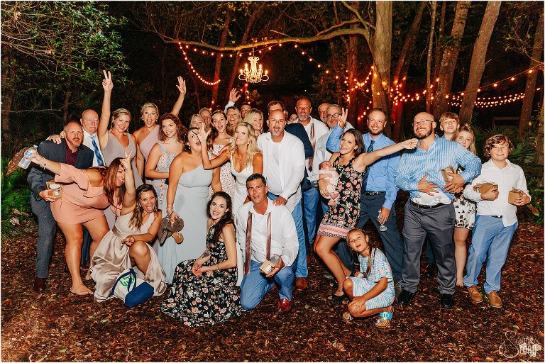 bride and groom surrounded by all their loved ones in giant group photo at end of rustic barn wedding