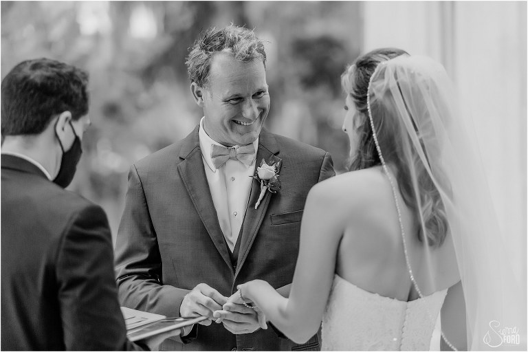 groom gives bride huge smile as he puts wedding ring on her finger during Kraft Azalea park wedding