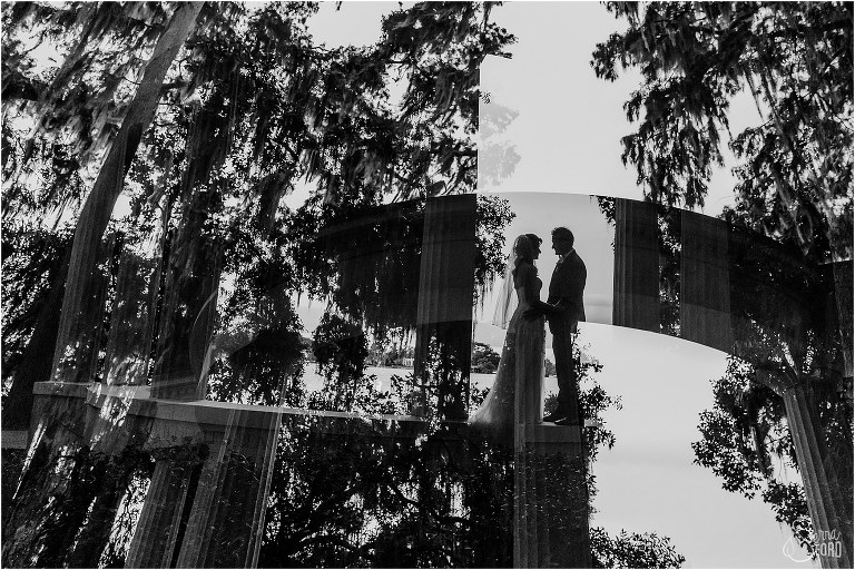 black and white double exposure of couple silhouetted against lake and the stone columns at Kraft Azalea park wedding