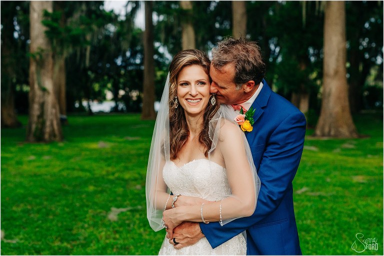 groom nuzzles bride's ear as he hugs her from behind at Kraft Azalea elopement