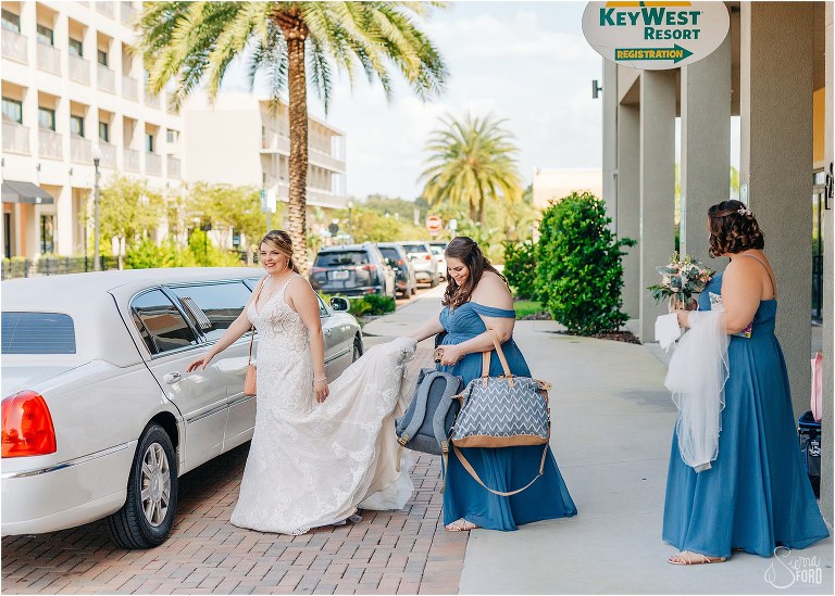 bridesmaids carry all the bags & help bride into limo to head to Tavares Pavilion wedding