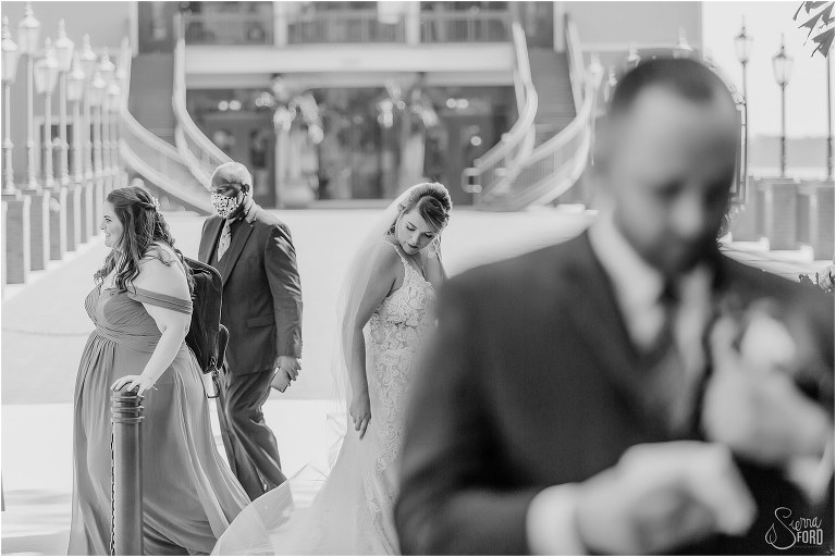 bride adjusts train as groom places handkerchief in pocket while both prepare for first look at Tavares Pavilion wedding