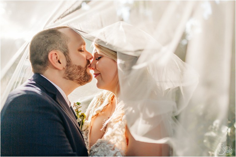groom kisses bride's nose as veil closes around them at Tavares Pavilion wedding