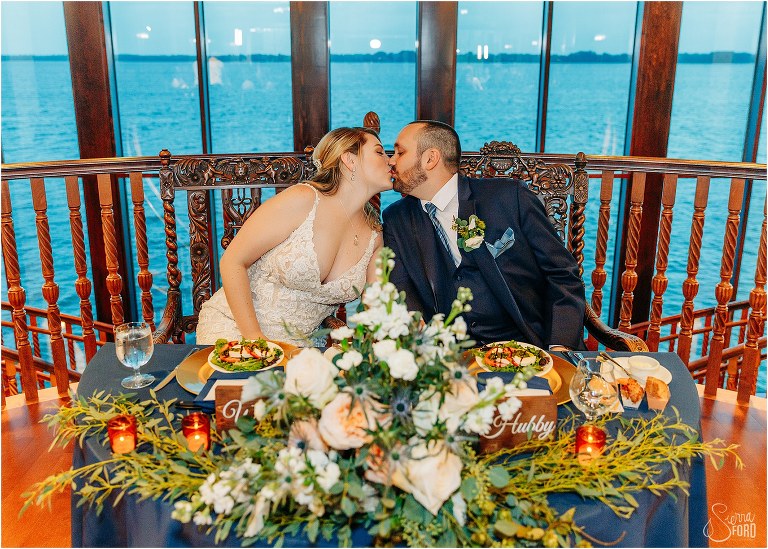 bride & groom share kiss at sweetheart table at Tavares Pavilion wedding