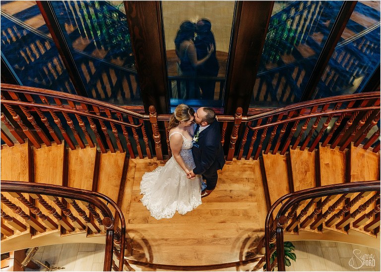 groom kisses bride's forehead on landing of grand staircase at Tavares Pavilion wedding