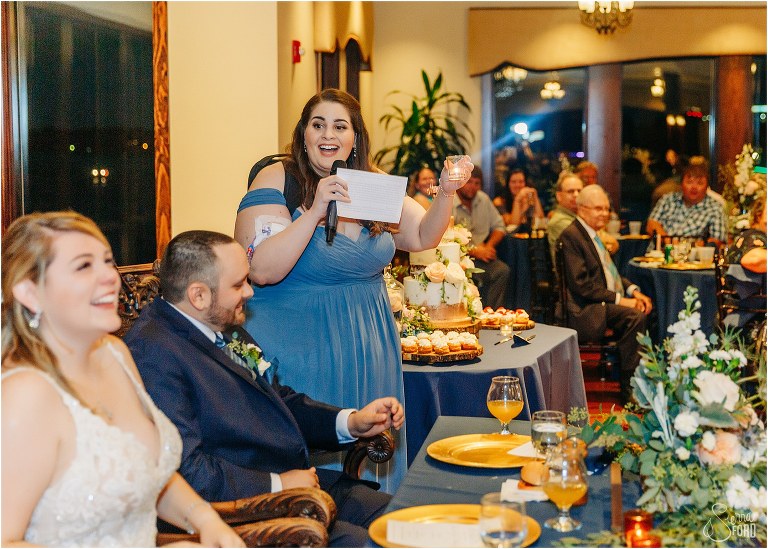 bride and groom laugh as maid of honor raises candle for toast at Tavares Pavilion wedding