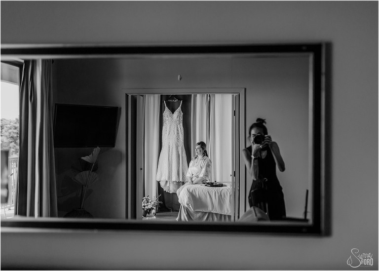 photographer in mirror as bride looks off before putting on dress at Tavares Pavilion wedding