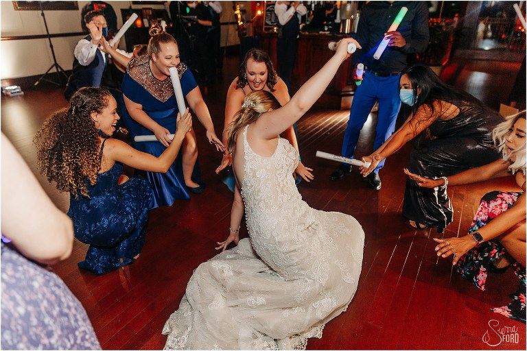 bride drops it like it's hot surrounded by girlfriends on the dance floor at Tavares Pavilion wedding