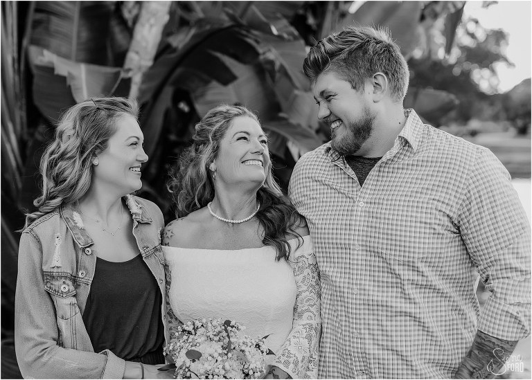 bride smiles up at her two children at St. Pete backyard wedding
