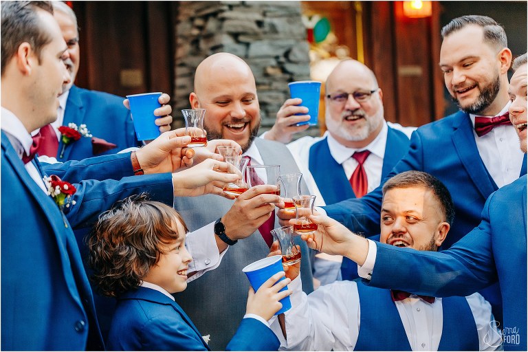 groom cheers his groomsmen as they enjoy shots of whiskey before rustic Apopka wedding