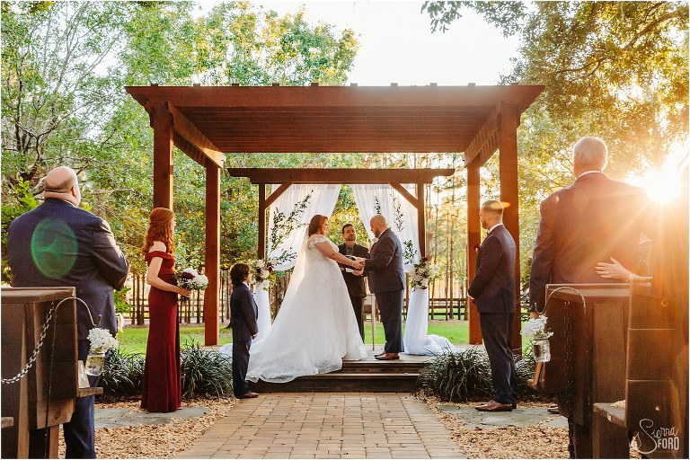 bride and groom say "I do" under large wooden altar at rustic Apopka wedding