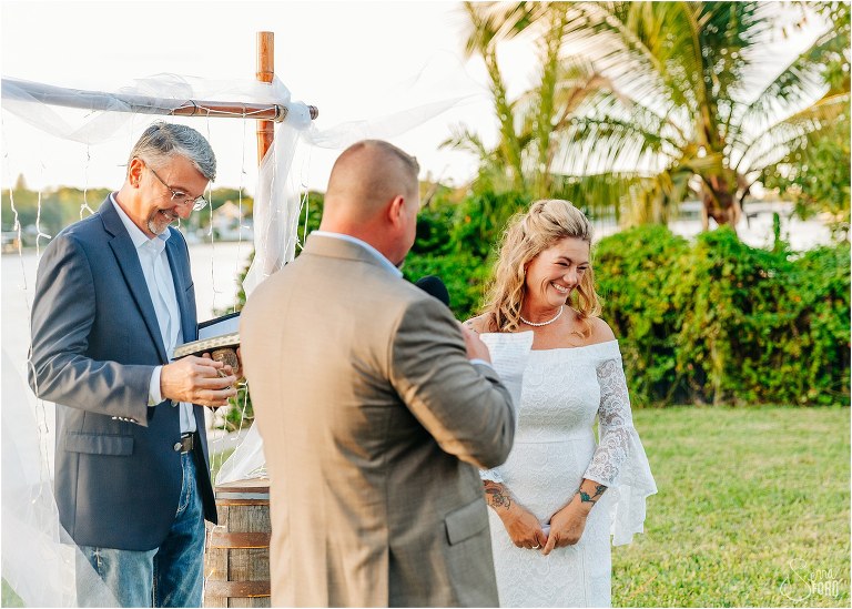 bride looks lovingly at grandkids as groom reads emotional vows at St. Pete backyard wedding