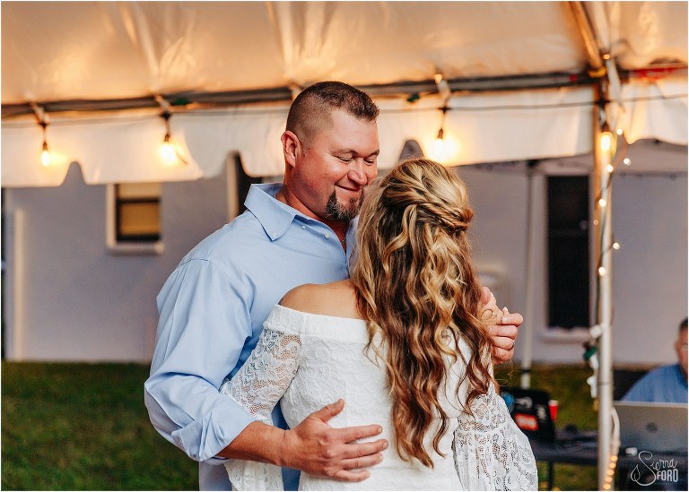 groom smiles down at bride during first dance at St. Pete backyard wedding