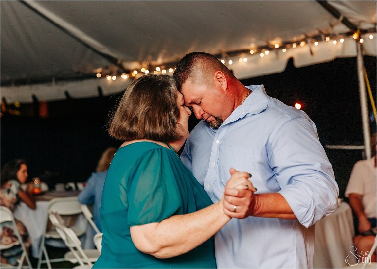 groom and mother share emotional moment with foreheads together during St. Pete backyard wedding reception