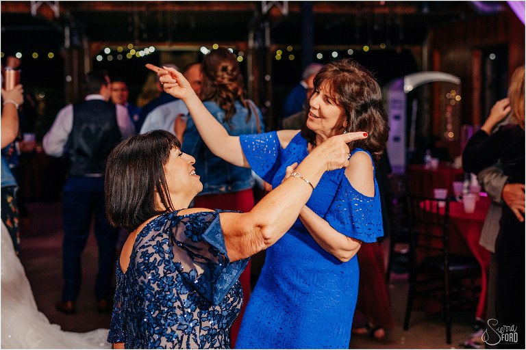 mothers of bride and groom dance together 
