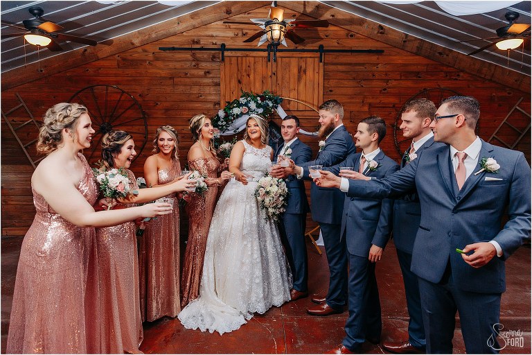 bride & groom cheers with wedding party at Hidden Barn wedding