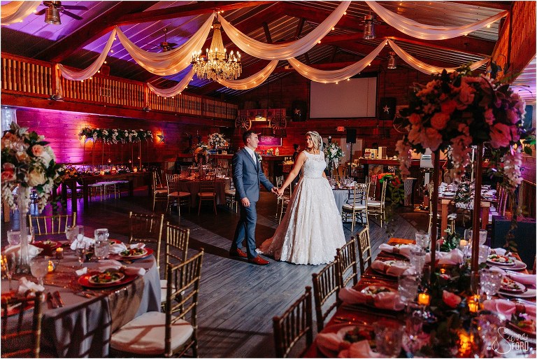 bride leads groom through reception room at Hidden Barn wedding