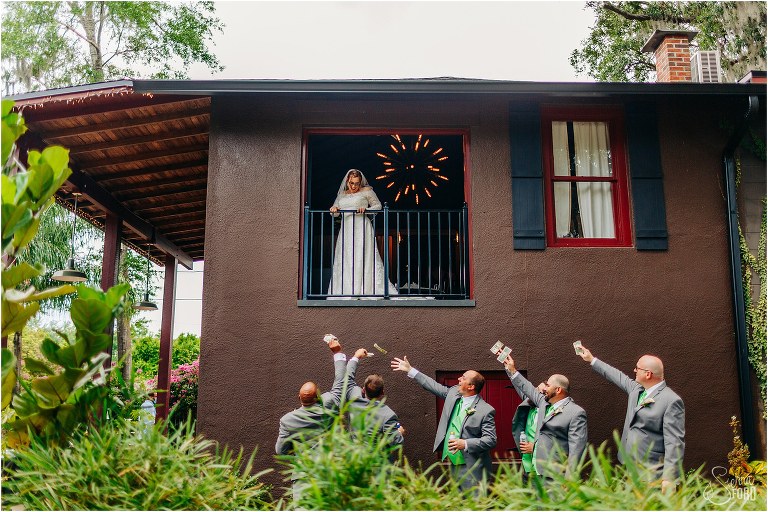 groomsmen throw money towards bride from below window before The Acre Orlando wedding