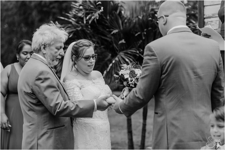 father of bride joins his daughter's hand with her soon-to-be husband's at The Acre Orlando wedding