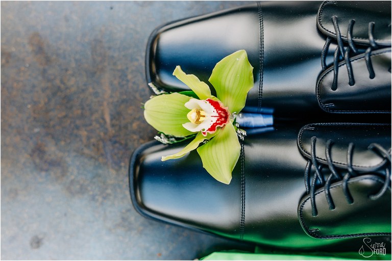 groom's boutonniere rests on his black patent leather shoes before The Acre Orlando wedding