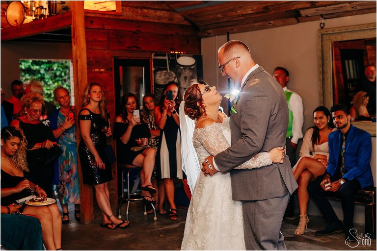 bride and groom share first dance as husband and wife surrounded by loved ones at The Acre Orlando wedding
